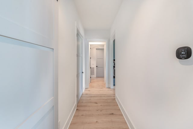 hallway with light hardwood / wood-style floors