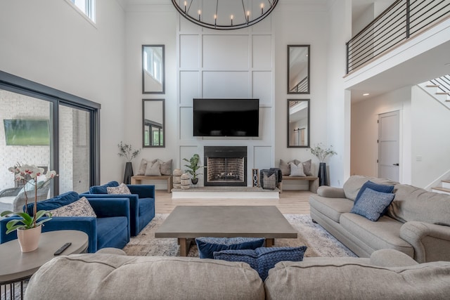 living room featuring a high ceiling, light hardwood / wood-style flooring, and a notable chandelier