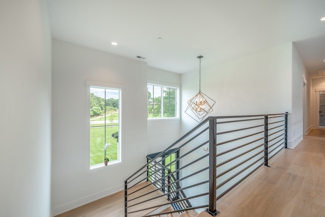 staircase featuring wood-type flooring and a chandelier