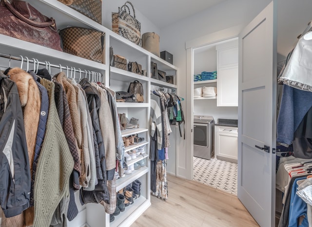 spacious closet featuring washer / dryer and light hardwood / wood-style flooring