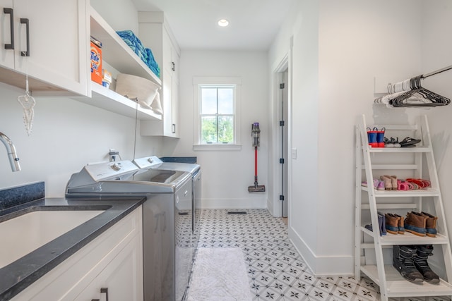 washroom with cabinets, separate washer and dryer, and sink