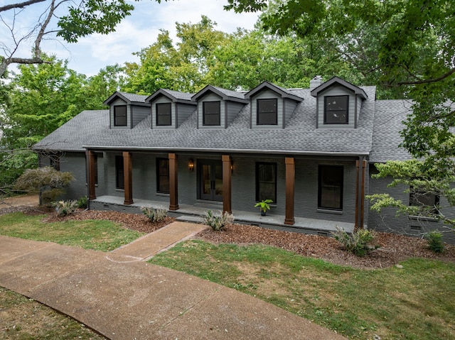 new england style home with a front yard and a porch