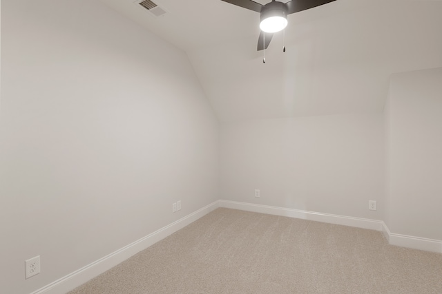 carpeted spare room featuring ceiling fan and vaulted ceiling