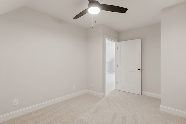 spare room featuring light colored carpet, ceiling fan, and lofted ceiling