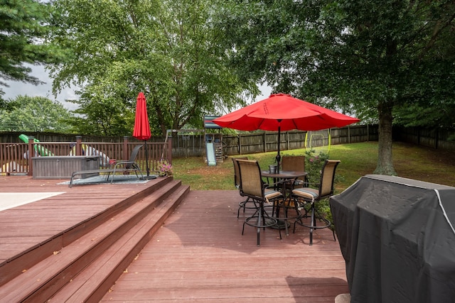 wooden deck with a playground, area for grilling, and a yard