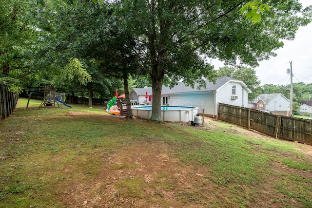 view of yard featuring a playground and a fenced in pool