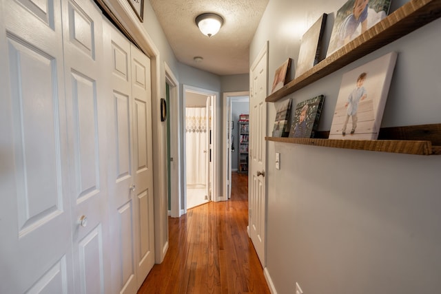 hall featuring hardwood / wood-style flooring and a textured ceiling