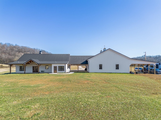 back of property featuring a lawn and a carport