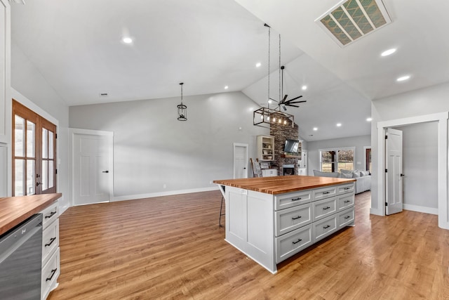 kitchen with decorative light fixtures, dishwasher, butcher block countertops, and a center island