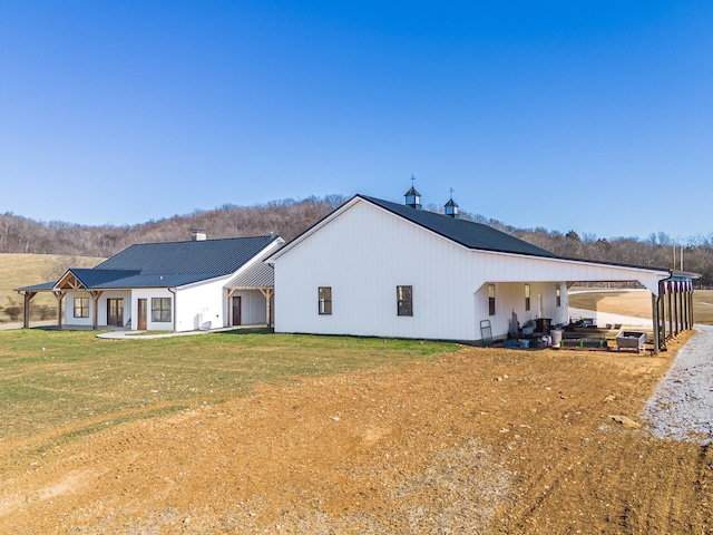 back of house with a carport and a yard