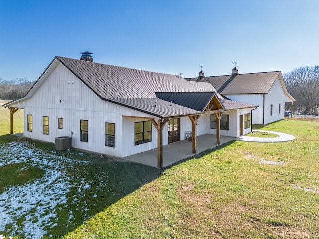 rear view of house with a patio area, a yard, and central AC