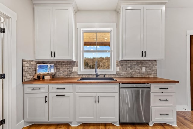 kitchen with sink, butcher block countertops, stainless steel dishwasher, and white cabinets