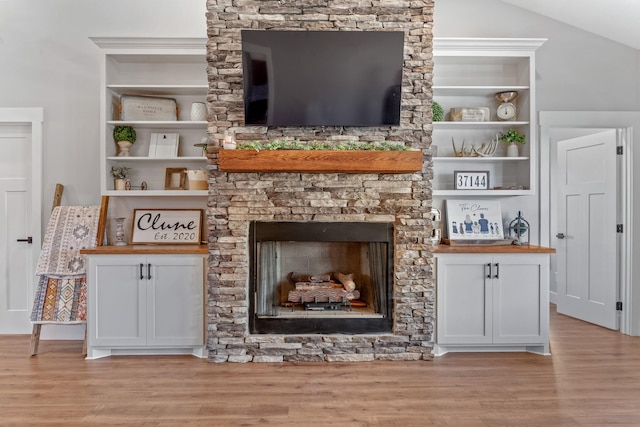 living room featuring light hardwood / wood-style flooring, lofted ceiling, and a fireplace