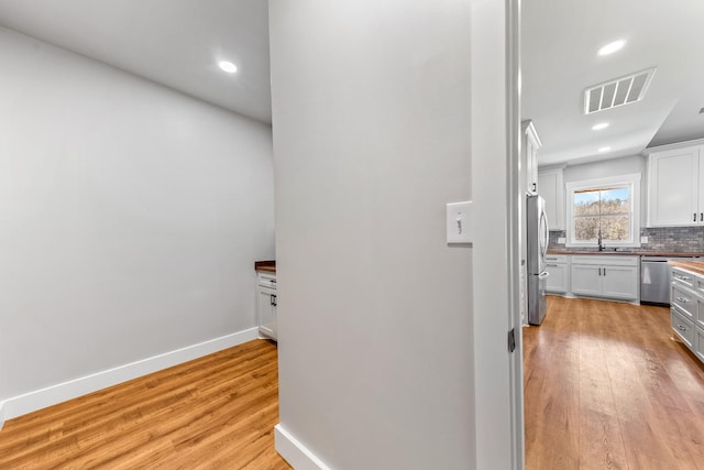 hall with sink and light hardwood / wood-style flooring