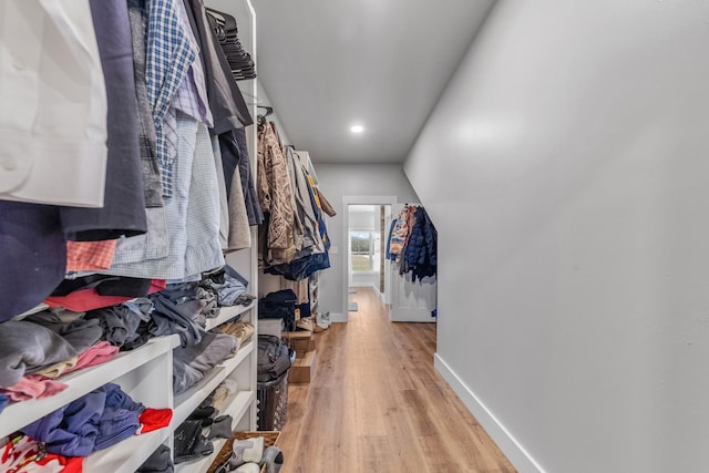 walk in closet featuring vaulted ceiling and light hardwood / wood-style flooring