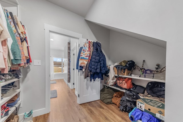 walk in closet featuring vaulted ceiling and light hardwood / wood-style flooring