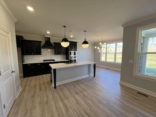 kitchen with backsplash, custom range hood, stainless steel appliances, a center island with sink, and a breakfast bar area