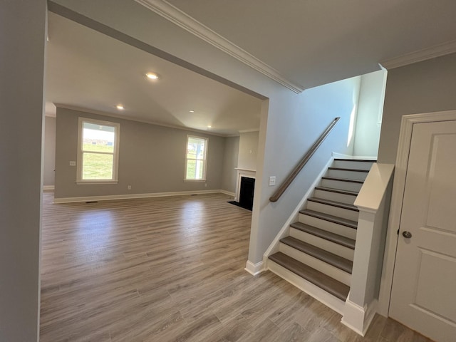 unfurnished living room featuring light hardwood / wood-style flooring and ornamental molding