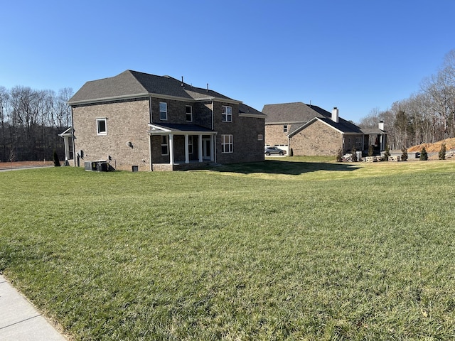 back of property featuring a yard and central AC