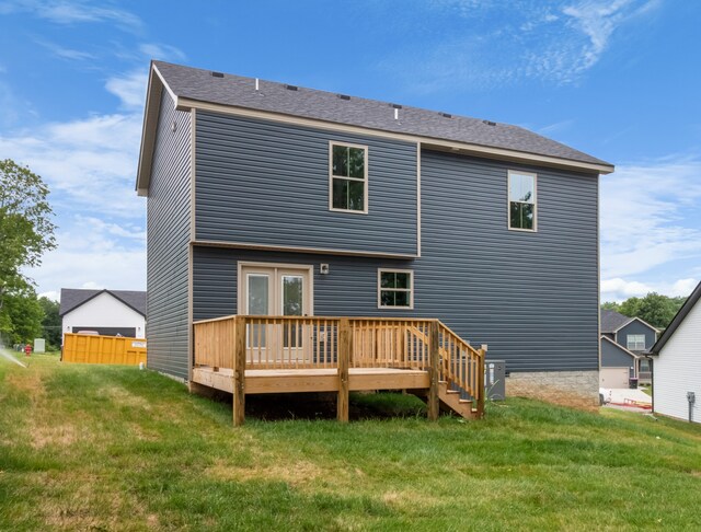 rear view of house featuring a yard and a wooden deck