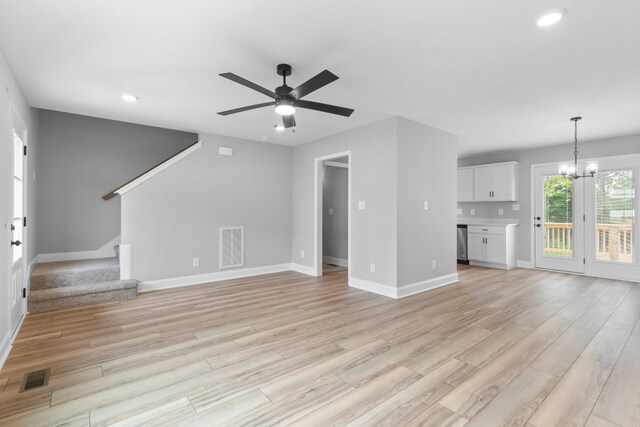 unfurnished living room with ceiling fan with notable chandelier and light hardwood / wood-style floors