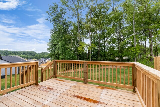 wooden terrace featuring a lawn