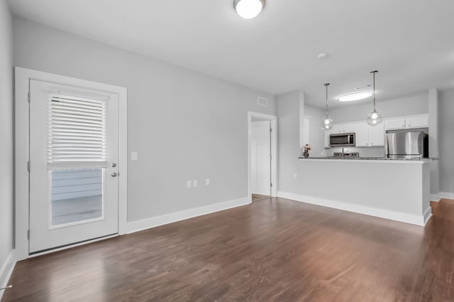 unfurnished living room featuring dark hardwood / wood-style floors