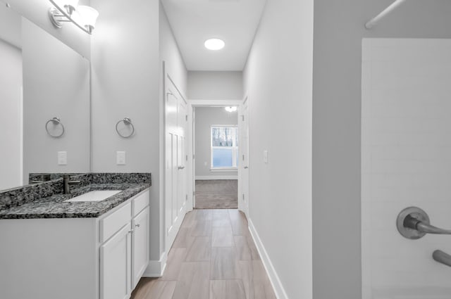 bathroom featuring a shower, hardwood / wood-style floors, and vanity