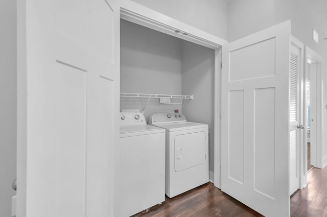 washroom with dark hardwood / wood-style flooring and washing machine and dryer