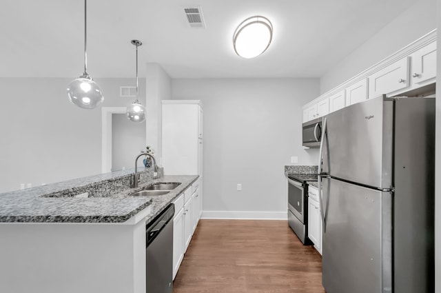 kitchen with white cabinetry, sink, pendant lighting, appliances with stainless steel finishes, and hardwood / wood-style flooring