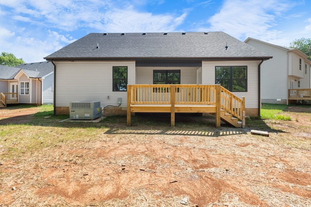 rear view of house featuring a wooden deck, a yard, and central AC unit