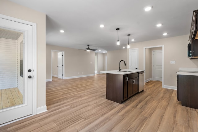 kitchen featuring ceiling fan, dishwasher, hanging light fixtures, light hardwood / wood-style flooring, and an island with sink