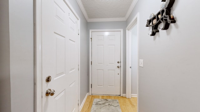 entryway with crown molding, a textured ceiling, and light wood-type flooring