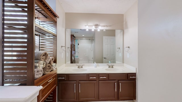 bathroom featuring a shower with door and vanity