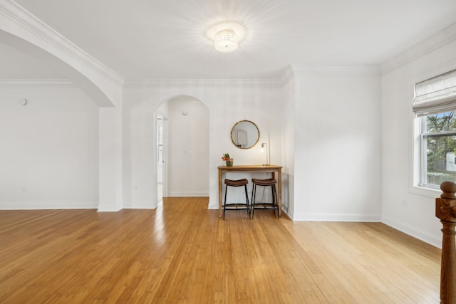 spare room featuring crown molding and light wood-type flooring