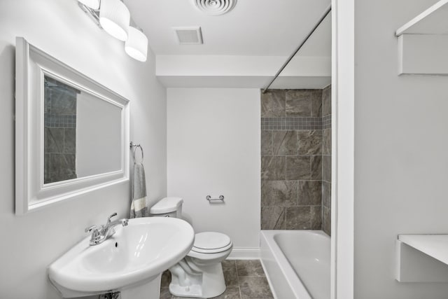 full bathroom with tile patterned flooring, tiled shower / bath combo, toilet, and sink