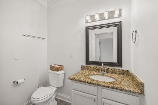 bathroom with vanity, toilet, and ornamental molding