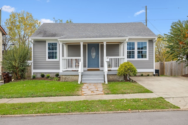 bungalow-style home featuring covered porch and a front yard