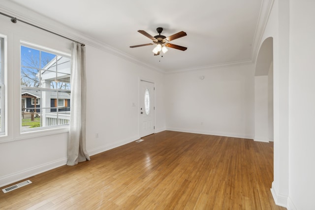 unfurnished room with light wood-type flooring, a wealth of natural light, and crown molding