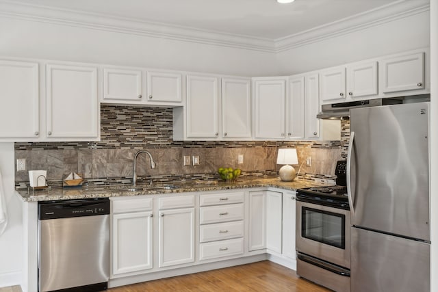 kitchen featuring white cabinetry, sink, light hardwood / wood-style floors, dark stone counters, and appliances with stainless steel finishes