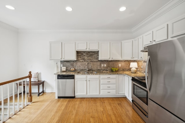 kitchen with white cabinets, stone countertops, light wood-type flooring, and appliances with stainless steel finishes