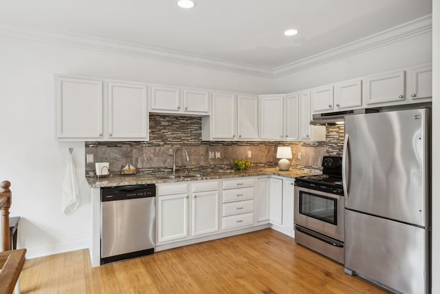 kitchen featuring dark stone countertops, white cabinetry, sink, and stainless steel appliances