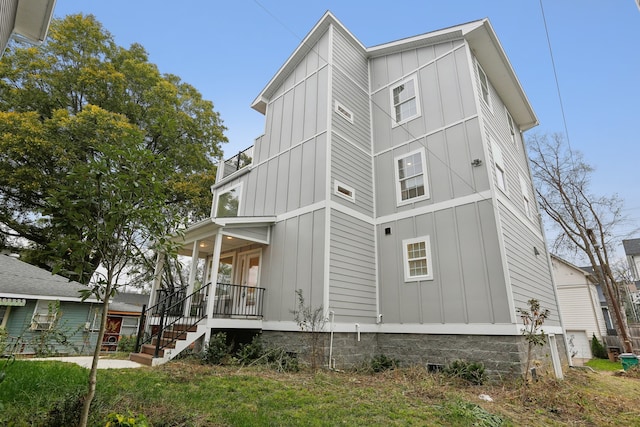 view of side of home featuring a porch and a yard