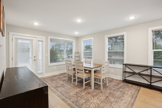 dining area featuring light wood-type flooring and a healthy amount of sunlight