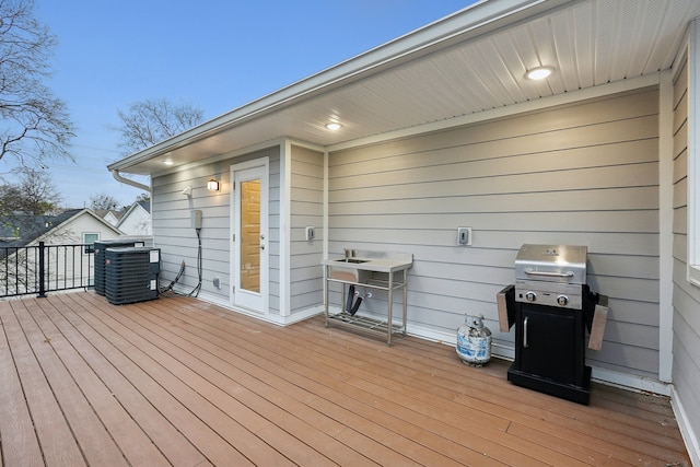 deck at dusk with cooling unit and area for grilling