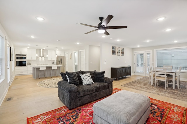 living room featuring light hardwood / wood-style floors and ceiling fan