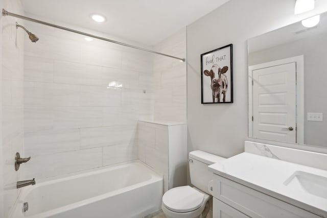 full bathroom with toilet, tiled shower / bath, and vanity