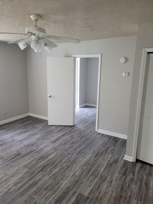 spare room with ceiling fan, dark wood-type flooring, and a textured ceiling