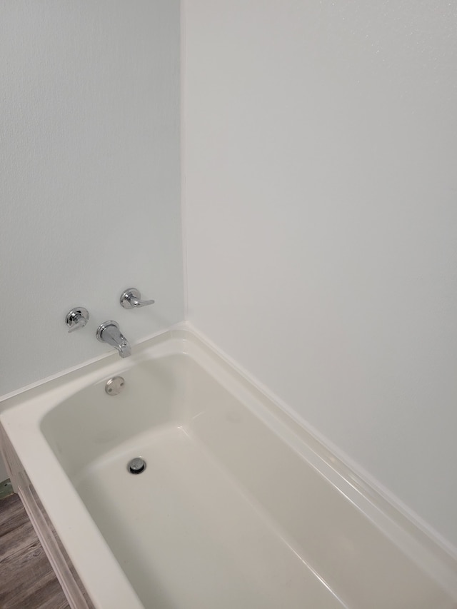 bathroom featuring a bath and wood-type flooring