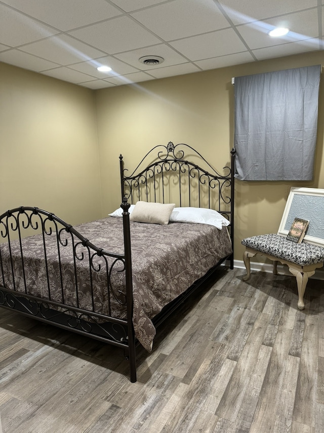 bedroom featuring a paneled ceiling and hardwood / wood-style flooring